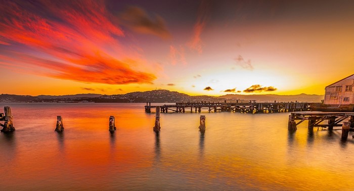 Sunset over the sea with a pier and building