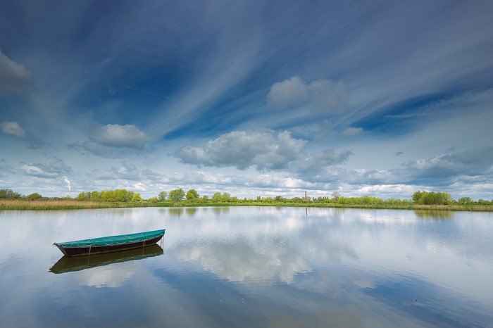 Boat on a calm lake with dramatic clouds