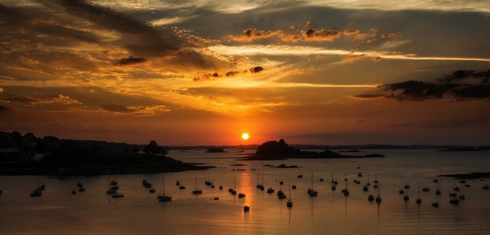 Sunset over a bay with sailboats