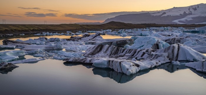 Icebergs floating in a glacial lake at sunset