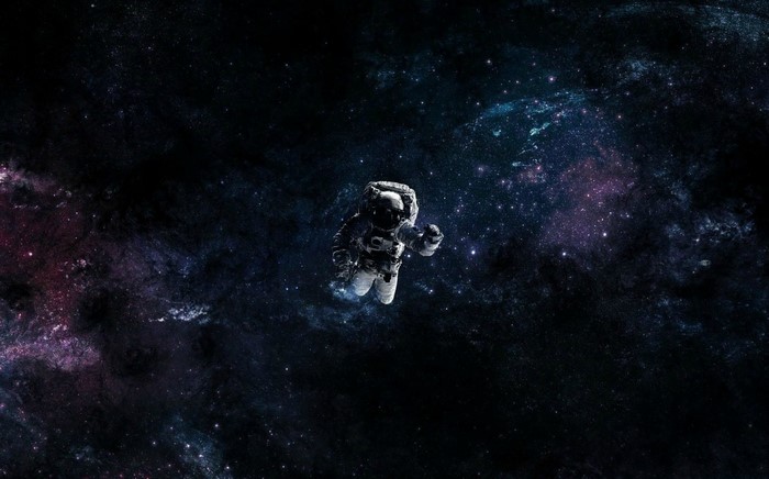 Astronaut floating in a colorful nebula in outer space