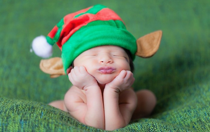 Baby in Elf Hat with Hands on Cheeks