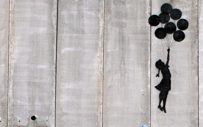 Girl with balloons graffiti on concrete wall