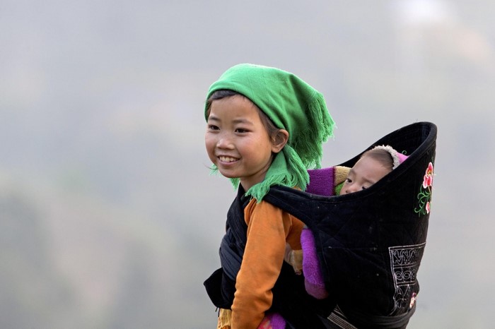 Girl carrying a baby on her back