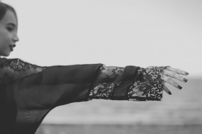 Woman in black lace clothing on a beach
