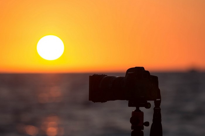 Camera on tripod at sunset over the ocean