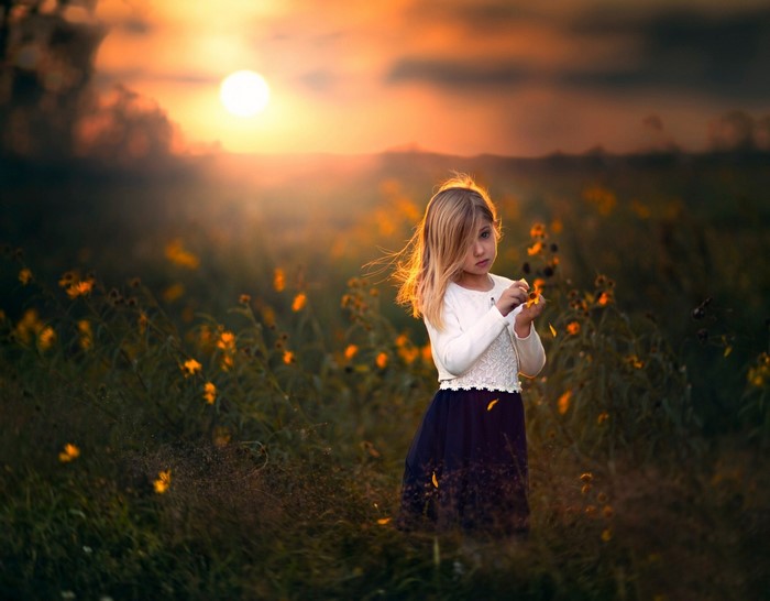 Girl in a field of flowers at sunset