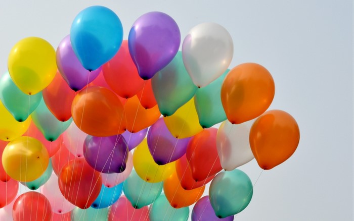 A large group of colorful balloons floating in the sky