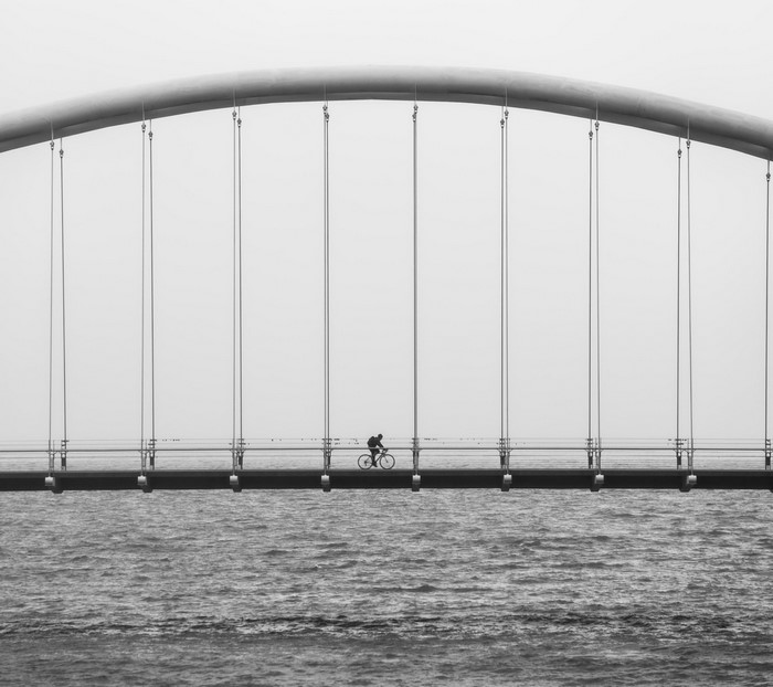 Cyclist on a bridge over water