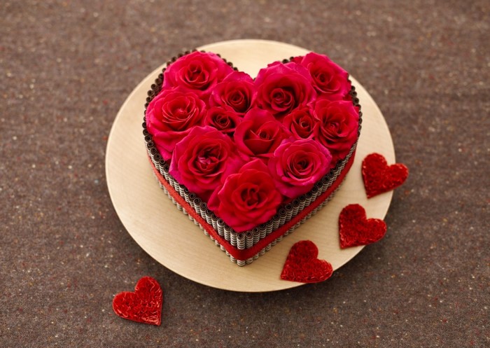 Heart-shaped cake decorated with red roses and chocolate