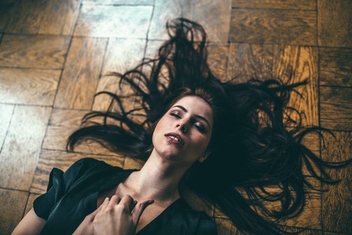 Woman lying on wooden floor with dark hair