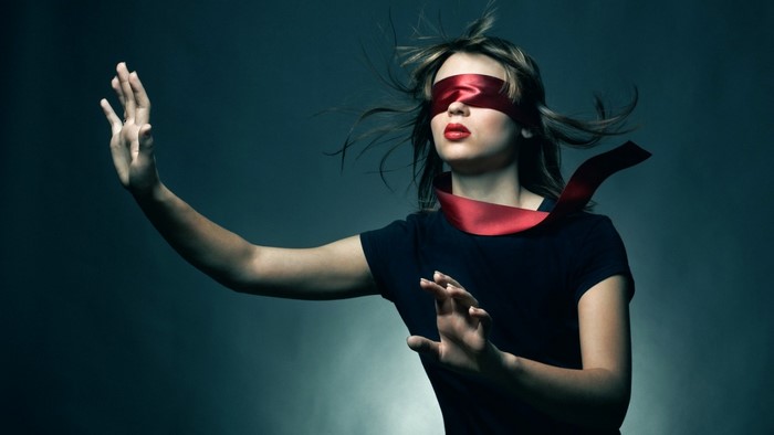 Woman blindfolded with red ribbon singing