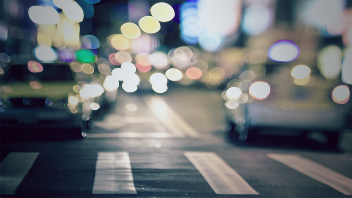 Blurred night city street with car lights and crosswalk