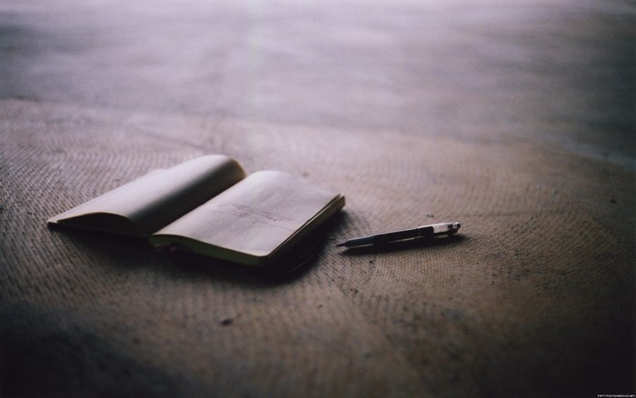 Open notebook and pen on a textured surface