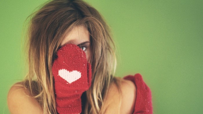 Woman wearing red mittens with heart