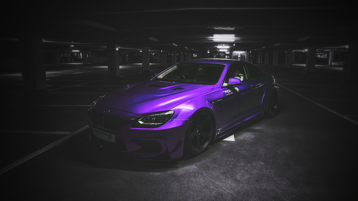 Purple BMW M6 parked in a dark parking garage