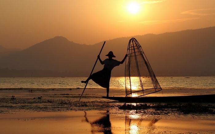 Fisherman with net at sunset on Inle Lake, Myanmar