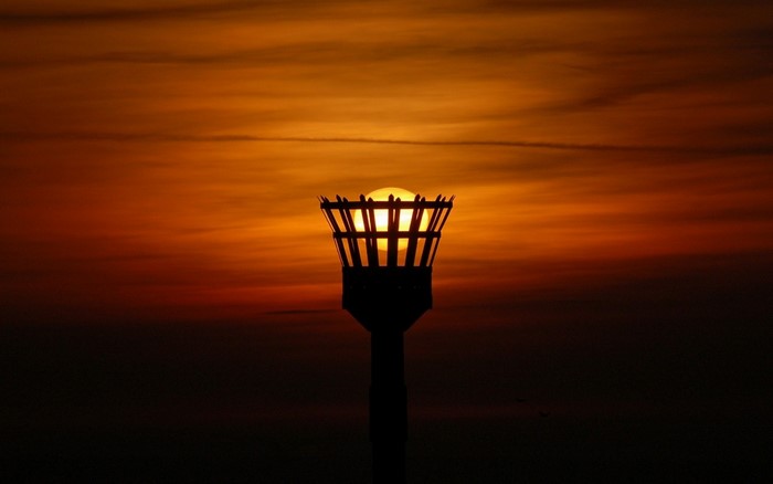 Silhouette of a torch against a sunset sky