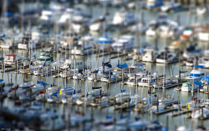 Boats docked in a busy marina with tilt-shift effect