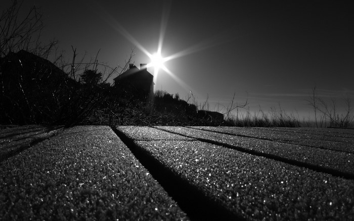 Sunlight over a house and wooden planks