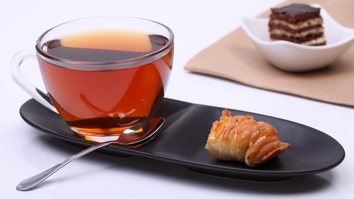 Tea with pastries on a black plate