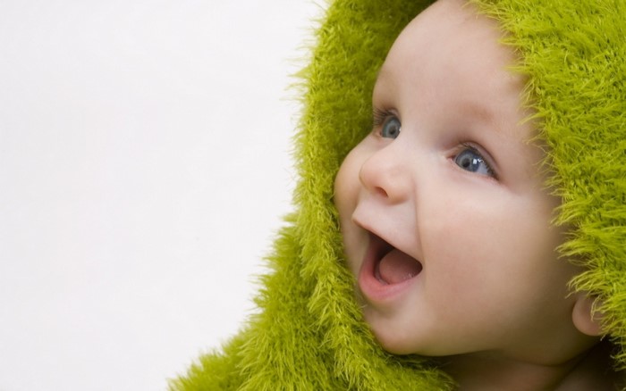 Baby wearing a green fuzzy hood