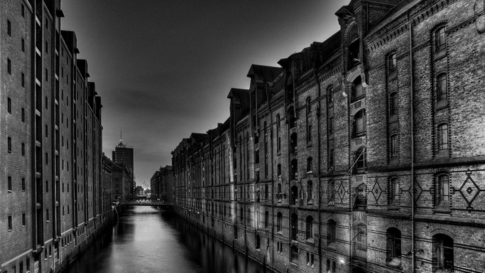 Monochrome cityscape with brick warehouses along a canal