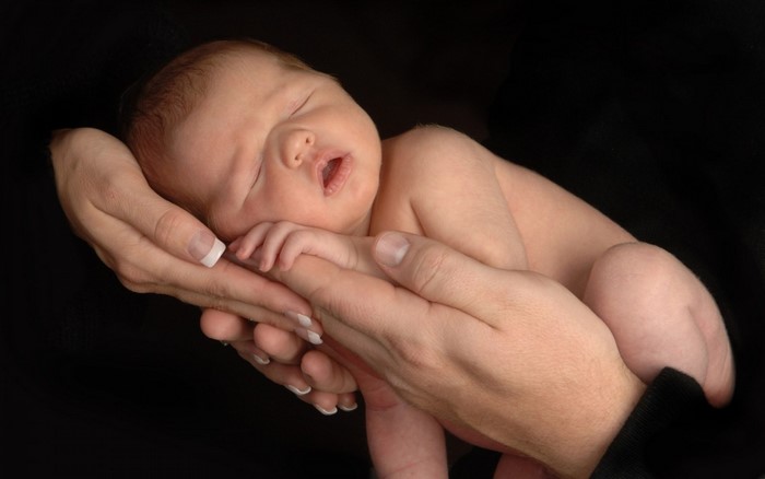 Newborn baby sleeping in hands