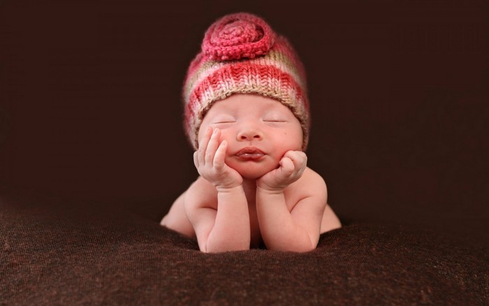 Baby wearing a pink and white striped hat