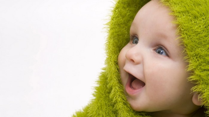 Baby wearing a green fuzzy hood