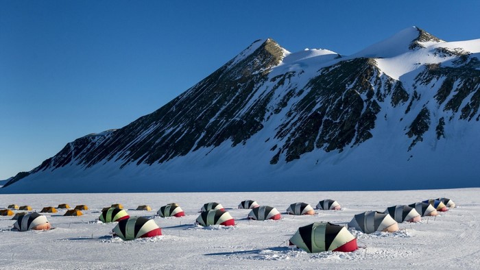 Tents in a snowy landscape with mountains