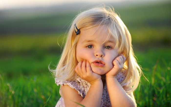 Young girl with blonde hair in a meadow