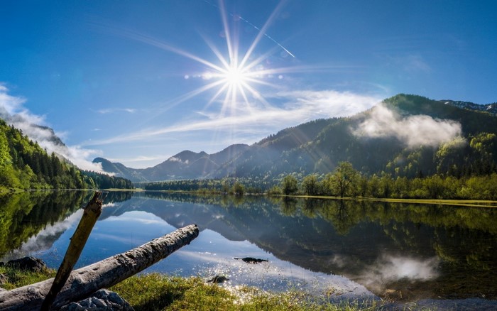 Sunlight over a mountain lake with reflections