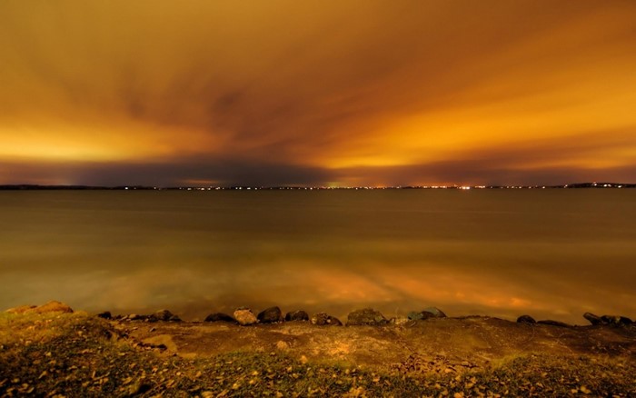 Orange sky over a body of water at night