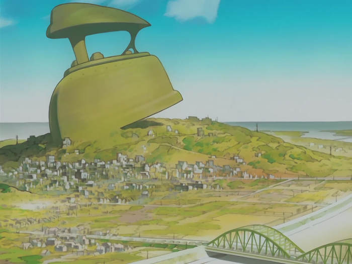 Giant iron on a hill overlooking a town and bridge