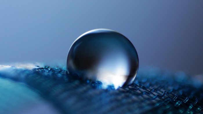 Close-up of a water drop on blue fabric