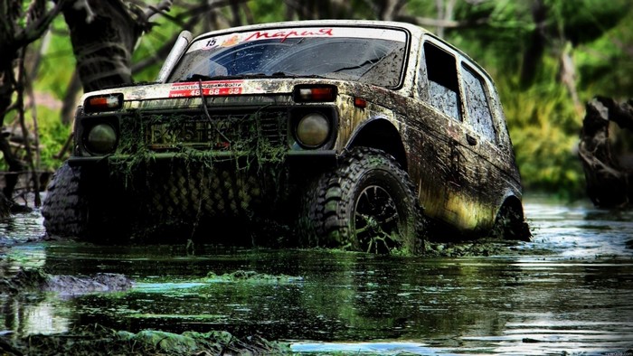 Muddy Lada Niva off-roading in water