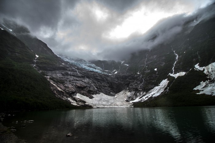 Glacier and lake in a mountainous landscape under clouds