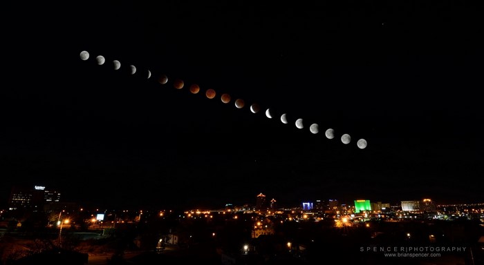 Lunar Eclipse Over City Skyline at Night