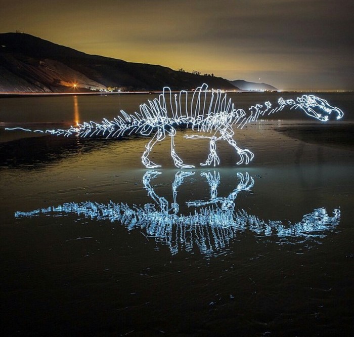 Light painting of dinosaur skeleton on beach at night