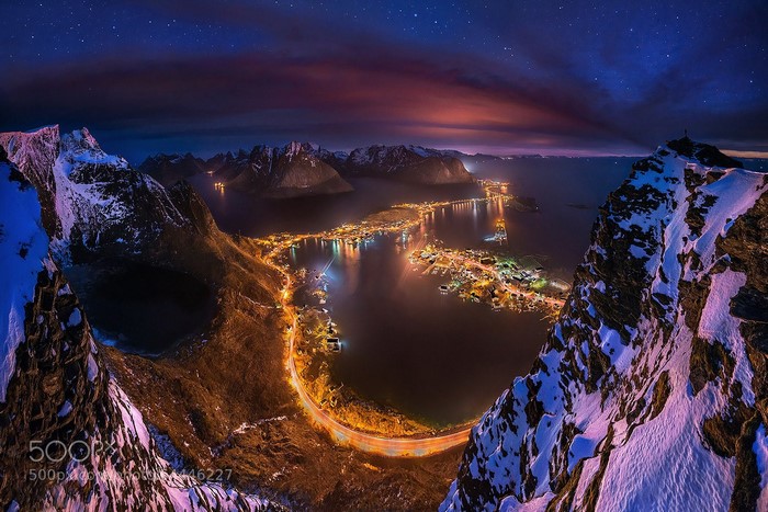 Aerial view of a Norwegian village at night with mountains and stars