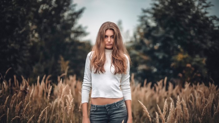 Woman in white top and jeans in a field