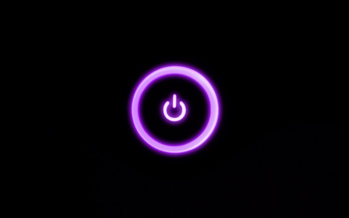 Purple neon power button on black background