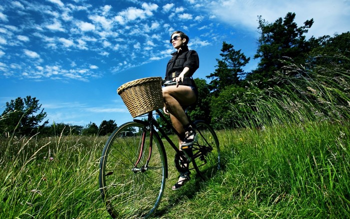 Woman on a bicycle in a grassy field