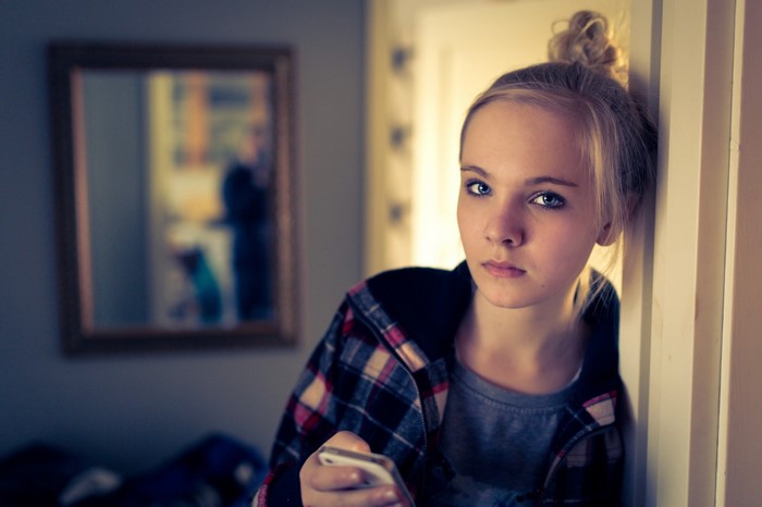 Girl with blonde hair holding a phone