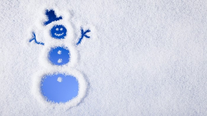 Snowman drawn in snow with blue background