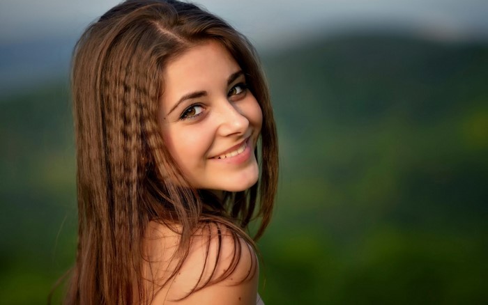 Smiling Young Woman with Long Hair in Nature
