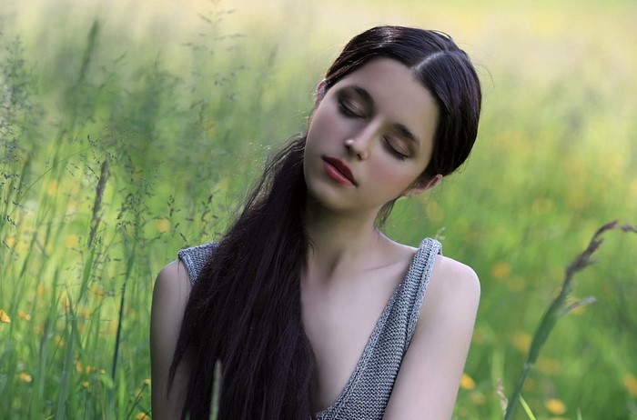 Woman with eyes closed in a field of grass