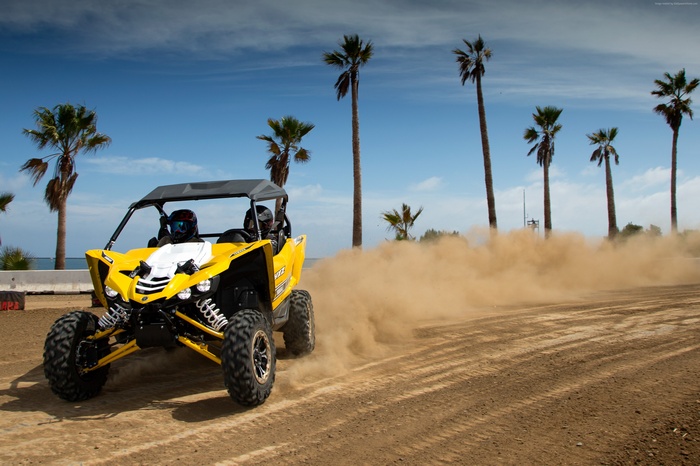 Yellow Yamaha YXZ1000R SE UTV driving on sand