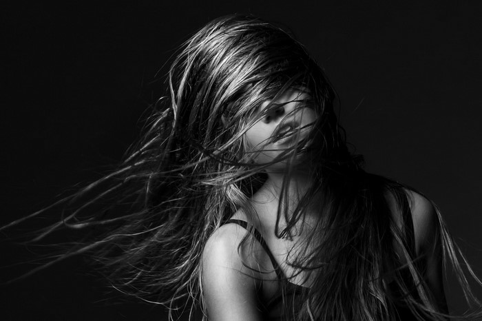 Monochrome portrait of a woman with long hair blowing